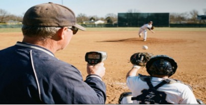 Coach using baseball radar gun to get pitch speed